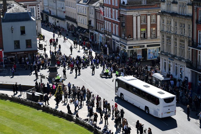 Police hold back the crowds as a coach arrives outside St George’s Chapel 