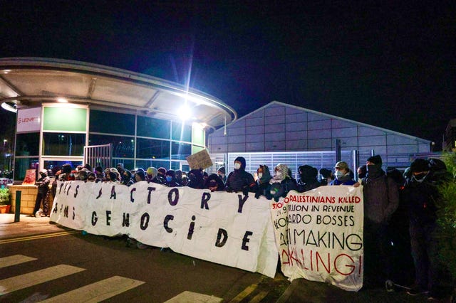 Protesters holding large placards outside building