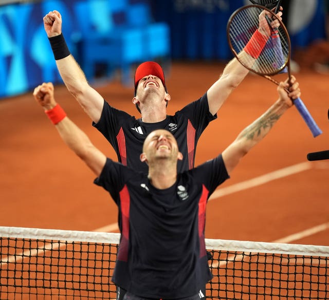 Andy Murray and Dan Evans celebrating with their arms in the ait