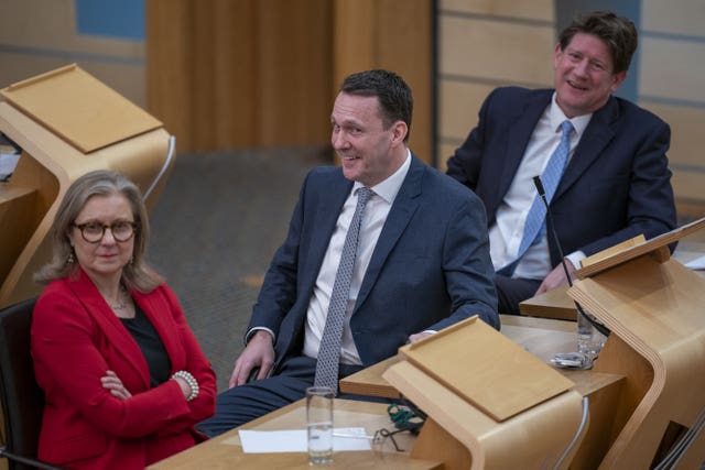 Russell Findlay smiling while seated in Parliament