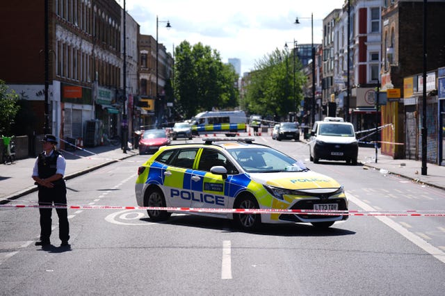 Police officers patrol at a cordon on Stoke Newington High Street 
