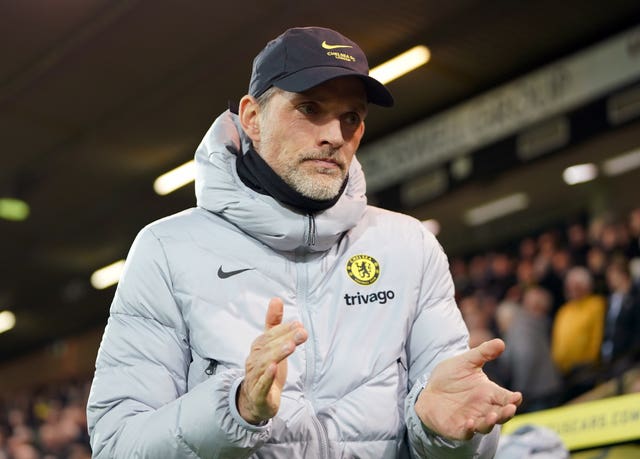 Thomas Tuchel, wearing a grey Chelsea coat, claps during a game