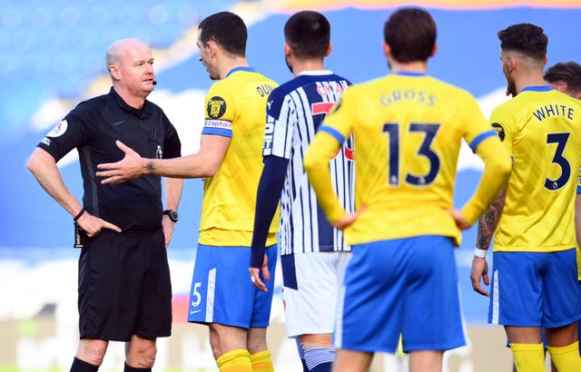 Referee Lee Mason (left) was left to explain to Brighton's Lewis Dunk why he had disallowed his free-kick.