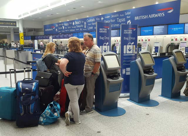 Passengers at the British Airways check-in desk at Gatwick Airport (Gareth Fuller/PA)