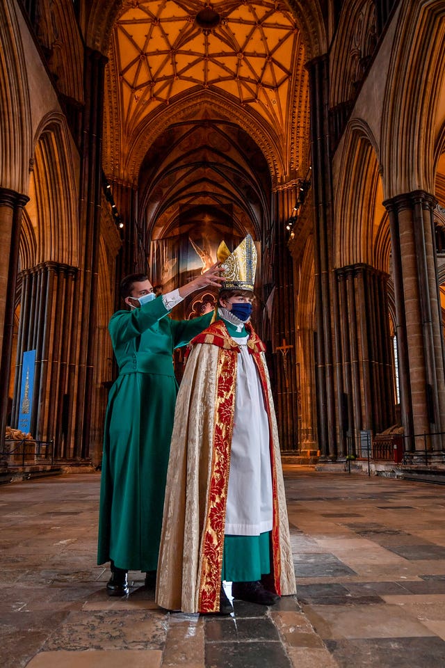 Verger Joseph Davies helps Chorister Bishop Sebastian Kunzer fit his mitre during rehearsal for the Feast of St Nicholas at Salisbury Cathedral (Ben Birchall/PA)