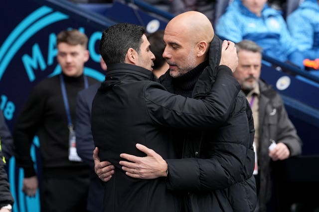 Manchester City manager Pep Guardiola and Arsenal manager Mikel Arteta embrace on the touchline before a game