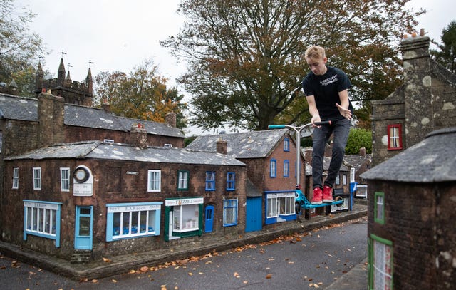 Charlie Sibley, from Wimborne’s StreetLight Project, scooters through the streets of Wimborne Model Town and Gardens in Dorset 