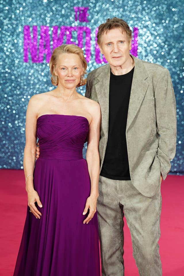 Liam Neeson and Pamela Anderson posing for a photo at a red carpet event