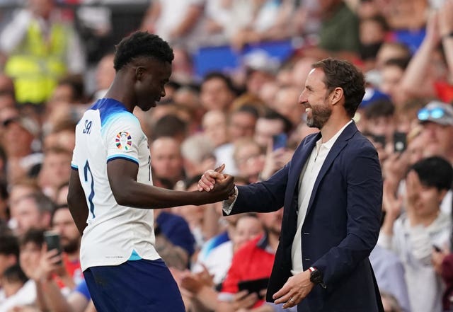 Bukayo Saka is congratulated by manager Gareth Southgate after being substituted
