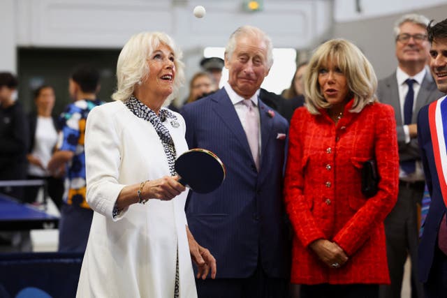 Queen Camilla plays table tennis next to the King and France's First Lady Brigitte Macron at a sports centre in Saint-Denis, Paris