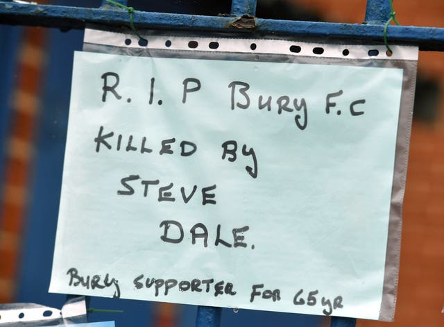 Messages from supporters are placed on a fence outside Gigg Lane
