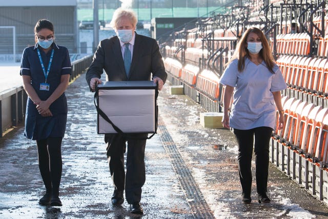 Prime Minister Boris Johnson loads doses of the Oxford/AstraZeneca coronavirus vaccine for mobile distribution at Barnet FC’s ground, The Hive (Stefan Rousseau/PA)