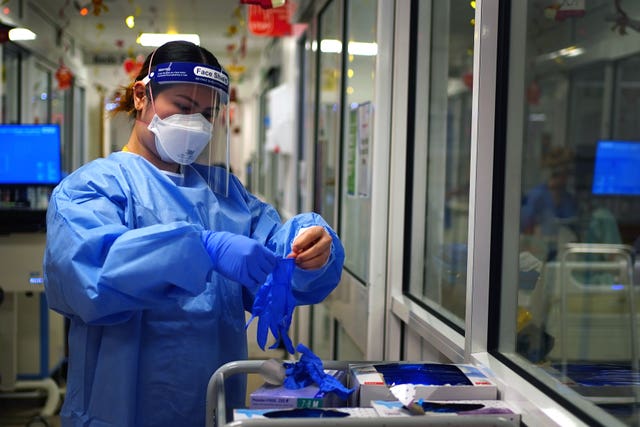 A nurse puts on PPE in a ward for Covid patients at King’s College Hospital, in south east London