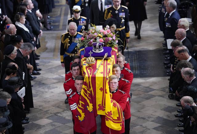 King Charles III, the Queen Consort, the Princess Royal and Vice Admiral Sir Tim Laurence follow behind the Queen's coffin as it is carried out of Westminster Abbey after her state funeral