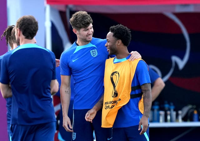England’s John Stones welcomes Raheem Sterling, right, back to training