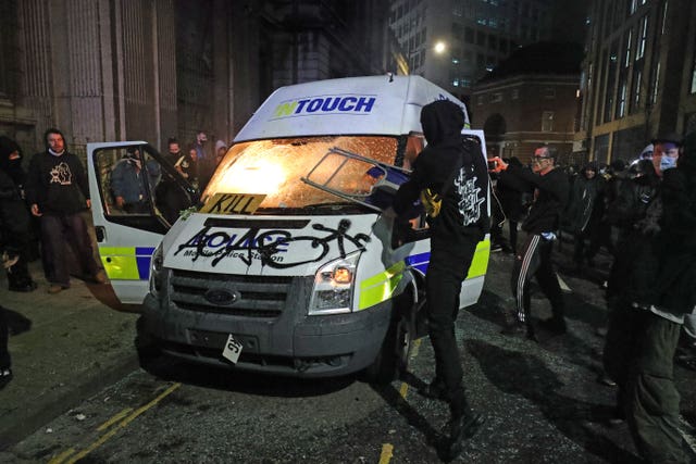Protesters set fire to a vandalised police van outside Bridewell police station in Bristol 
