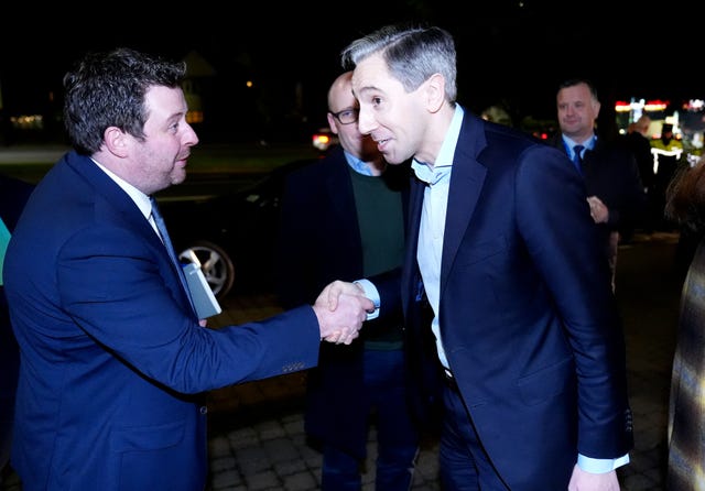 Simon Harris is greeted as he arrives at the meeting