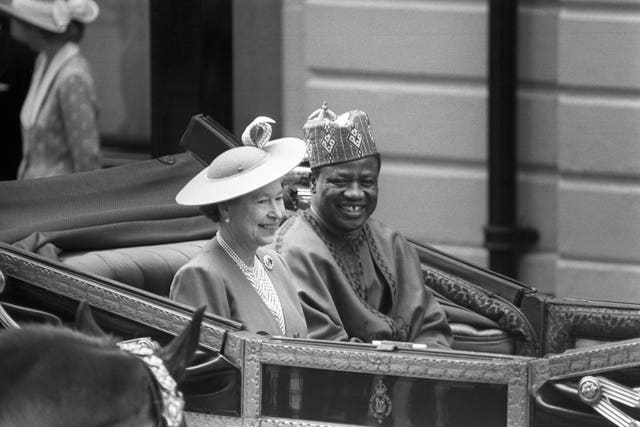 Queen Elizabeth II and Nigeria’s then-military ruler General Ibrahim Babangida, travelling in an open-top carriage from Victoria Station to Buckingham Palace in 1989
