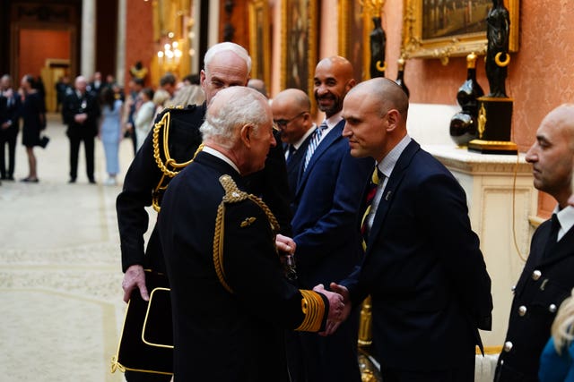 The King presents the Humanitarian Medal to Matthew Newport during a medal presentation at Buckingham Palace, London