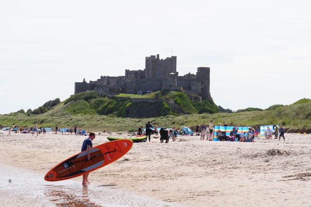 People enjoy the warm weather on Bamburgh Beach in Northumberland on August 11 2024 