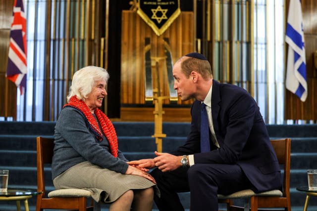 The Prince of Wales touches the hand of Renee Salt, 94, a Holocaust survivor, during a visit to the Western Marble Arch Synagogue in London (Toby Melville/PA)