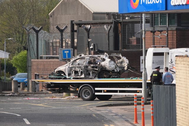 The remains of an exploded vehicle are removed from the scene 