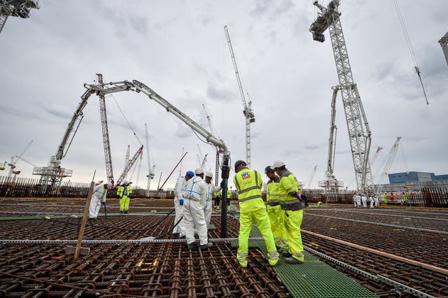 Construction workers stand on the base for the first reactor at Hinkley Point C power station near Bridgwater, Somerset 