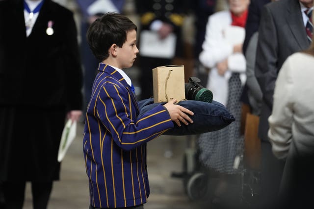 A child’s gas mask and box is carried to the High Altar in Westminster Abbey 