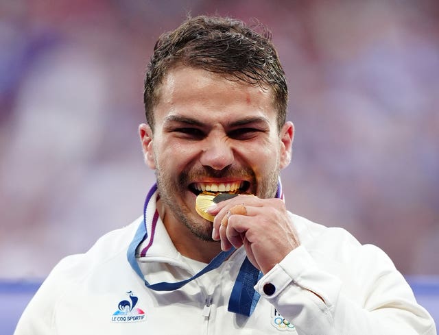 France’s Antoine Dupont bites his medal after winning Olympic rugby sevens gold