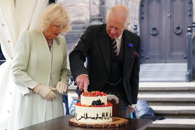 The King and Queen cut a cake made by 2020 Great British Bake Off winner Peter Sawkins as they attend a celebration at Edinburgh Castle to mark the 900th anniversary of the City of Edinburgh 