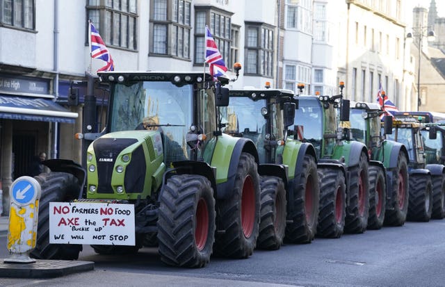 Green tractors flying Union flags lined up in a street in Oxford