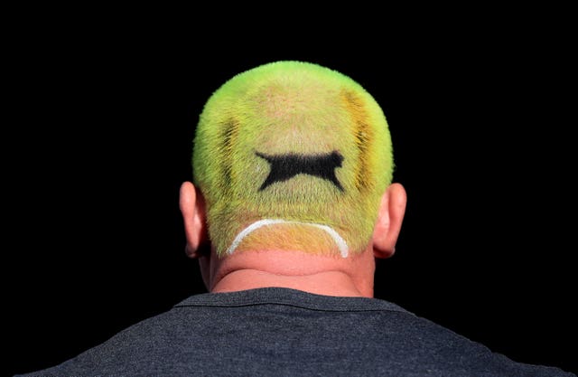 A fan with a tennis ball dyed into his hair on day one of Wimbledon