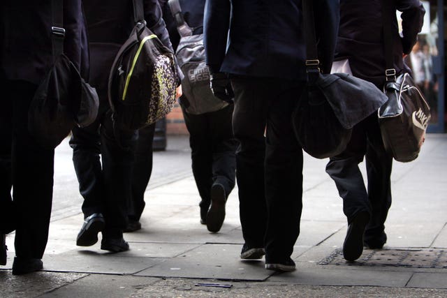 The legs of a group of school children walking to school