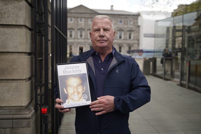 Errol Buckley holds a photo of his brother Jimmy Buckley, who died in the fire, as he arrives at Leinster House, Dublin 