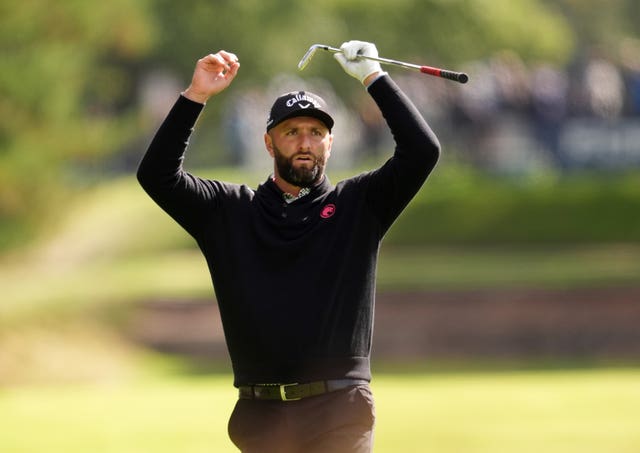 Jon Rahm raises both arms above his head