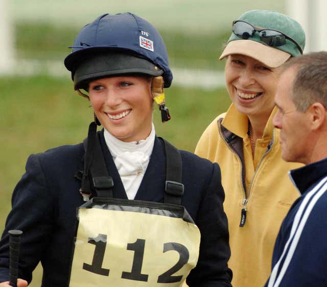 Zara Tindall, wearing a riding hat, with Anne, wearing a yellow coat