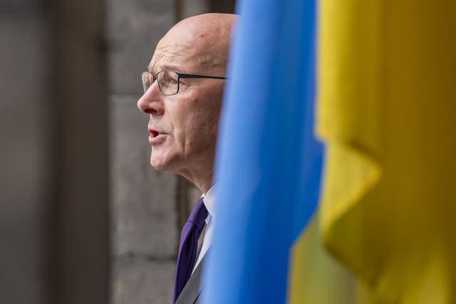 Side view of John Swinney speaking beside a Ukrainian flag