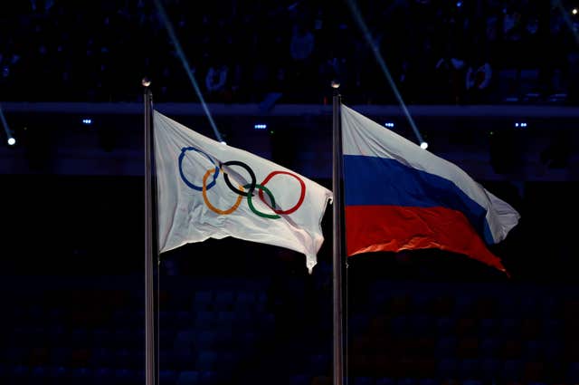 The Olympic flag next to Russia's flag at the 2014 Winter Olympics in Sochi
