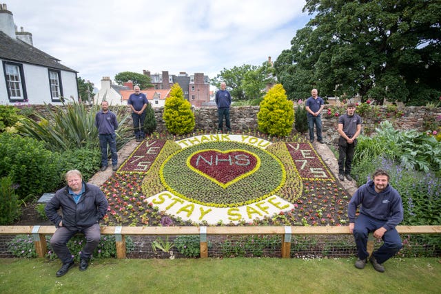 (clockwise from top) Iain Tait, Kyle Storrie, Rory Armatage, Scott Rowan, Johnn Stevens, Dave Brunton and Bruce Collins, from East Lothian Council’s Amenity Services stand alongside the floral display they created acknowledging the 75th anniversary of VE Day and thanking the NHS during the current Covid-19 pandemic in the Lodge Grounds at North Berwick