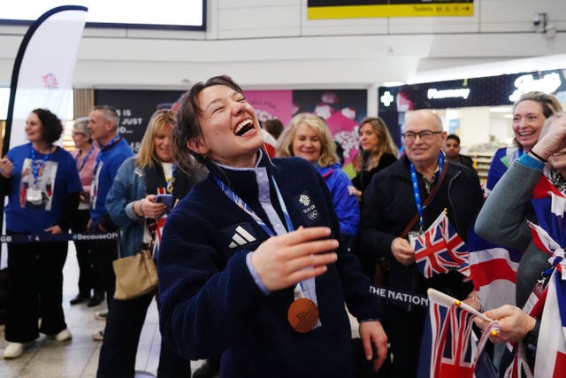 Zoe Atkin laughing as she returns to Great Britain at Gatwick Airport