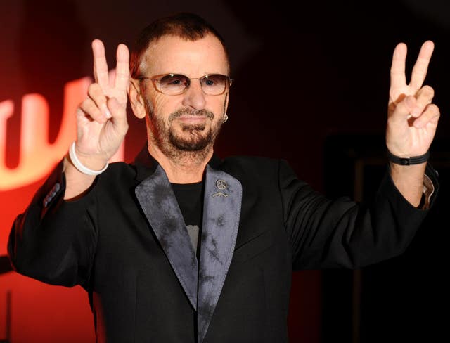 Ringo Starr throwing peace signs