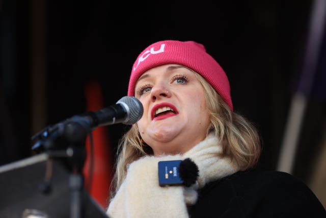 Headshot of Jo Grady speaking into a microphone, wearing a pink UCU hat