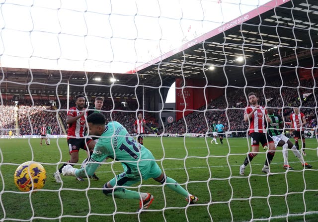 Goalkeeper Wes Foderingham dives in vain as Sheffield United’s Jack Robinson, foreground right, scores an own goal to put Brighton 3-0 up