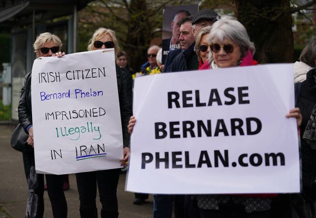 People attend a vigil for Bernard Phelan outside the Iranian Embassy in Dublin