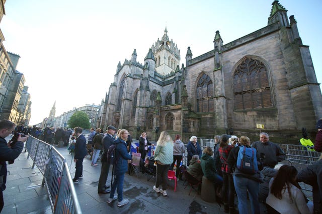 People gather outside St Giles’ Cathedral in Edinburgh ahead of the procession of Queen Elizabeth’s coffin from the Palace of Holyroodhouse to the cathedral