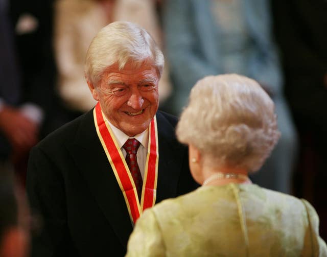 Sir Michael Parkinson receives his knighthood from the Queen at Buckingham Palace