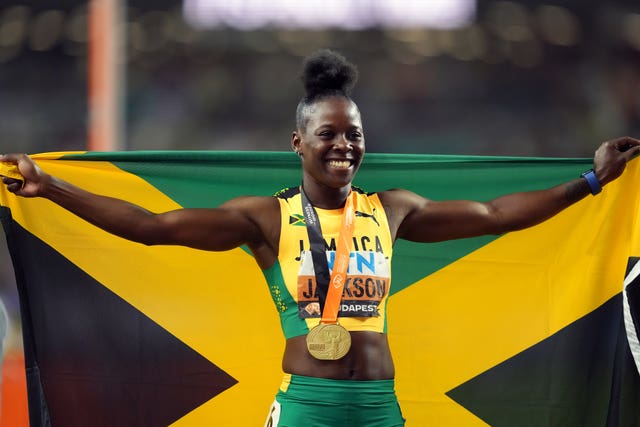 Jamaican sprinter Shericka Jackson poses with a gold medal and her country's flag