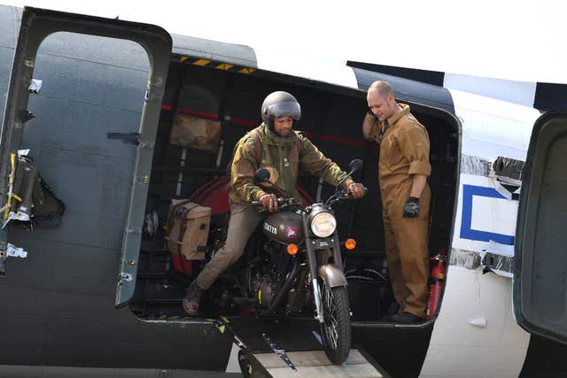 A Classic 500cc Pegasus motorbike is ridden out of a Dakota C-47 during its unveiling at Imperial War Museum Duxford (Joe Giddens/PA)