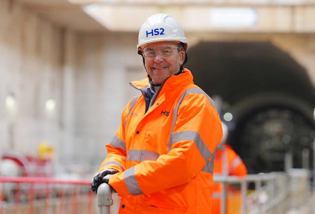 A man in an orange hi-vis jacket and hard hat 