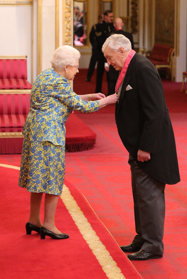 The Queen presenting Willie John McBride with his CBE